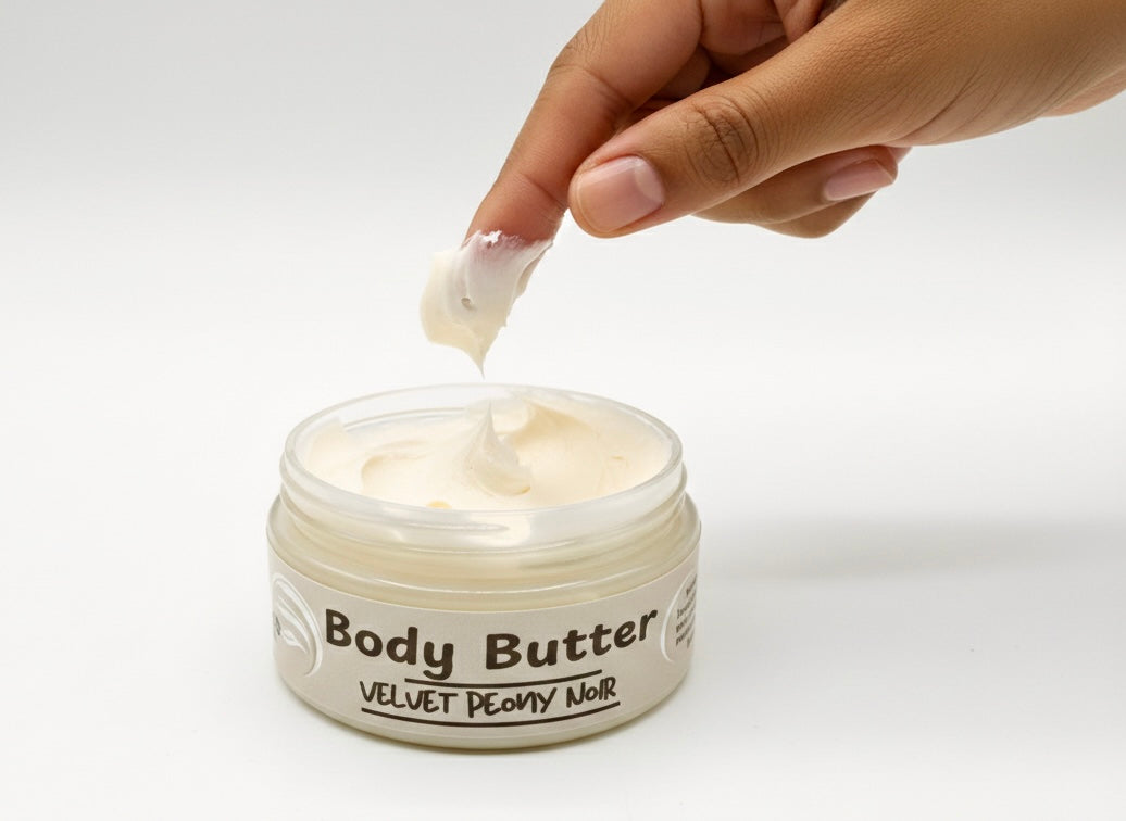 Hand applying Baiye whipped body butter with shea cocoa butter and squalane for all skin types from a jar with a white background